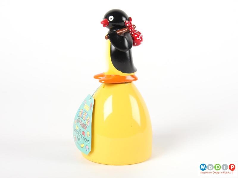 Side view of a Pingu sweet container showing the penguin holding a stick and knotted handkerchief over its shoulder.