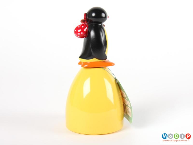 Side view of a Pingu sweet container showing the penguins wing held down by its side.