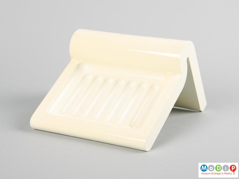 Side view of a wall mountable soap dish showing the ridged soap tray.