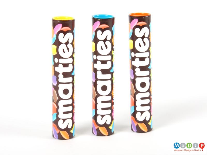 Side view of a Smarties tube showing three similar tubes.