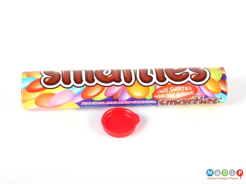 Side view of a Smarties tube showing the printed decoration and the lid.