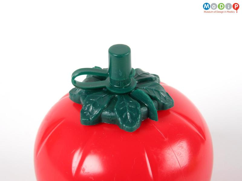 Close view of a tomato sauce bottle showing the leaves and stopper on the top.