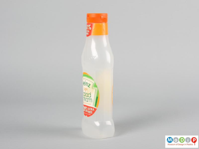 Side view of a salad cream bottle showing the orange cap and translucent body.