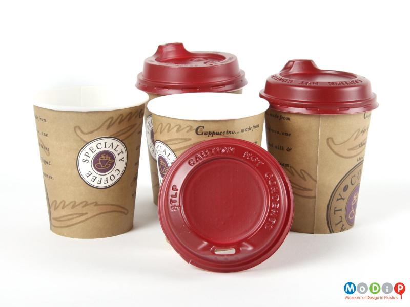 Side view  of three Smart Lids and paper cups showing the top of one of the lids.