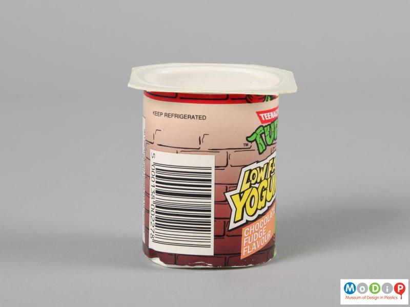 Side view of a yoghurt pot showing the printed label and wide sturdy lip.