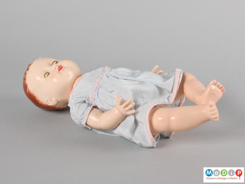 Side view of a Pedigree doll showing the doll laying down with eyes closed.