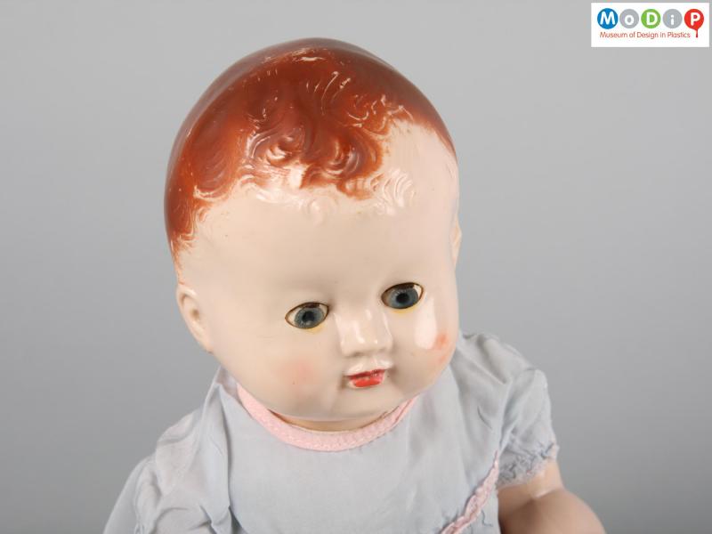 Close view of a Pedigree doll showing the face with moulded painted hair and eyes open.