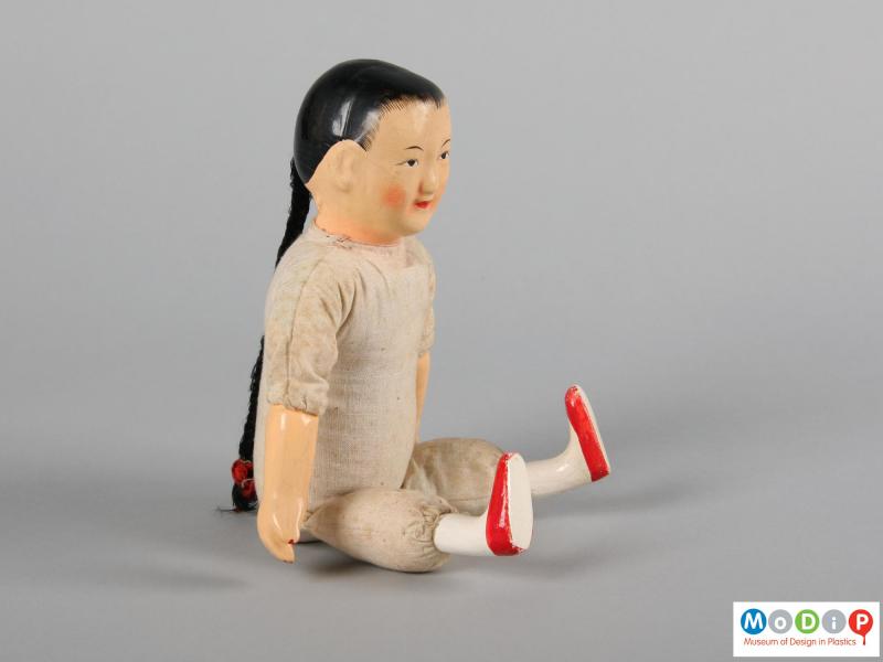 Side view of a doll showing the arms and the legs.