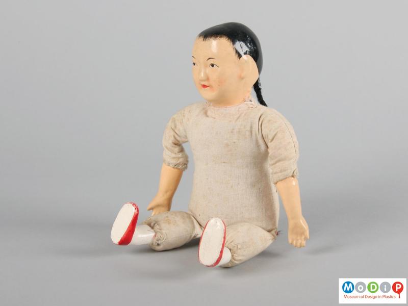 Side view of a doll showing the arms and legs.