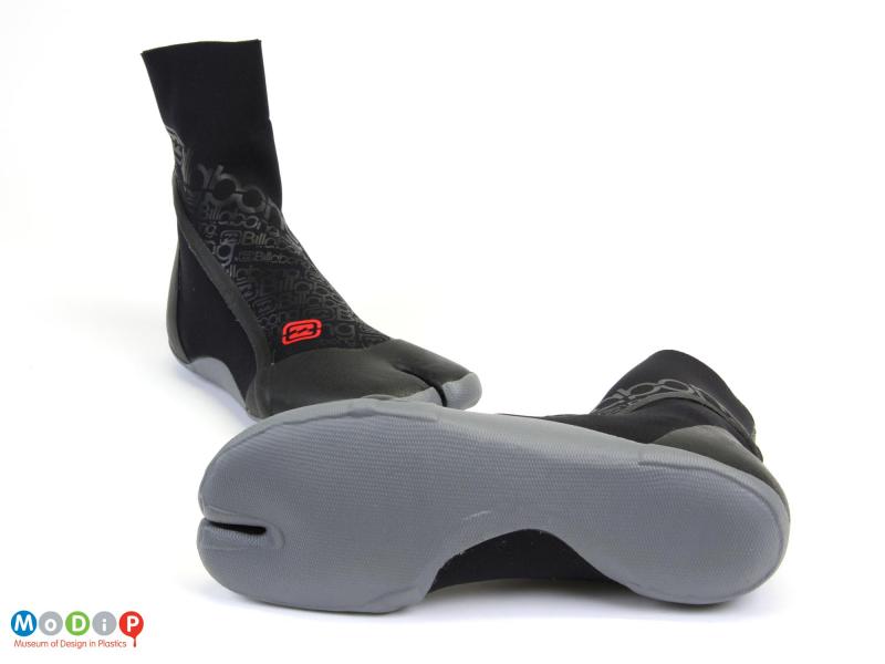 Underside view of a pair of surfing boots showing the rubberised sole.