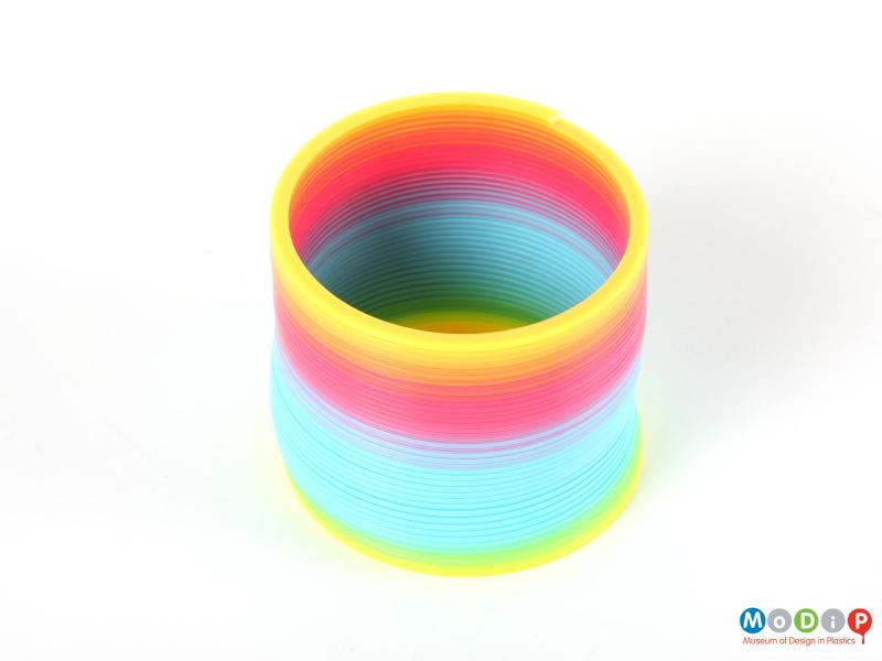 Top view of a plastic Slinky showing the full range of the colours.