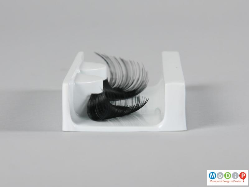 Side view of a pair of false eyelashes showing the varying lash lengths.
