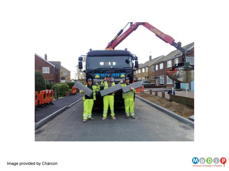Inuse view of a Durakerb showing three construction workers holding a kerb each in one hand - this image was provided by Charcon.