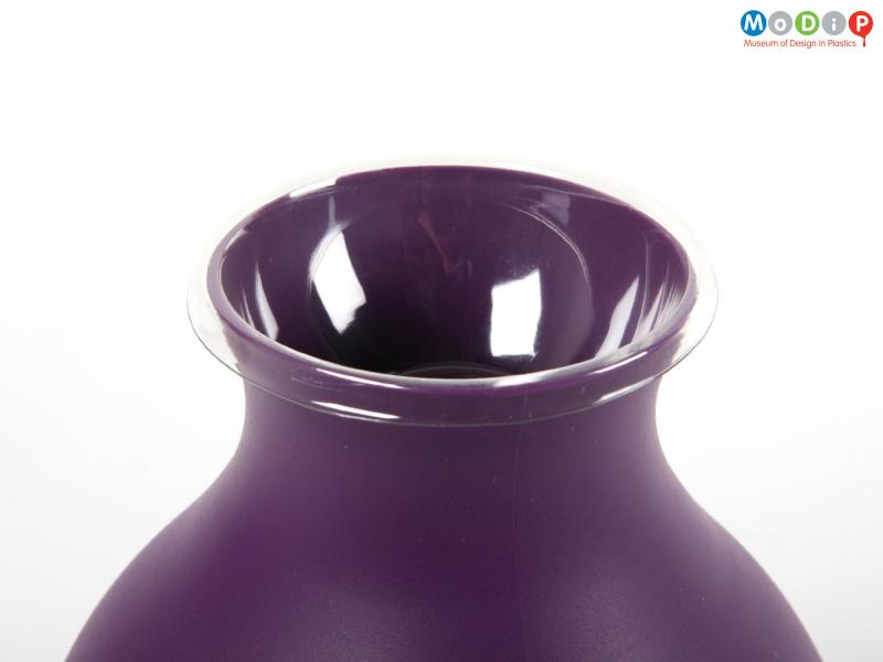 Close view of a Rubber vase showing the neck and mouth which is covered by a section of pacakging.