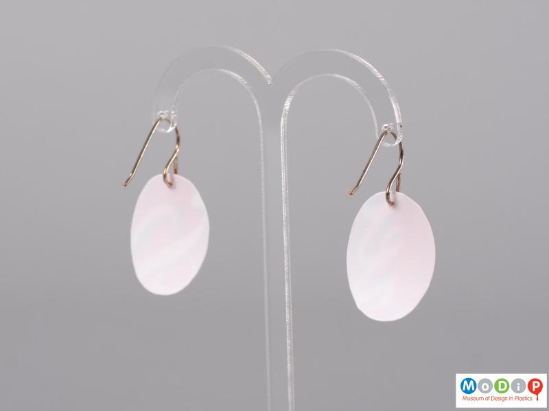 Rear view of a pair of Sour Cream pot earrings showing the plain white back of the material.
