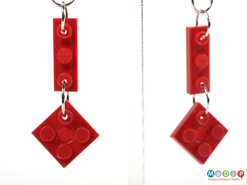Close view of a pair of earrings made of Lego showing the detail on the bricks.