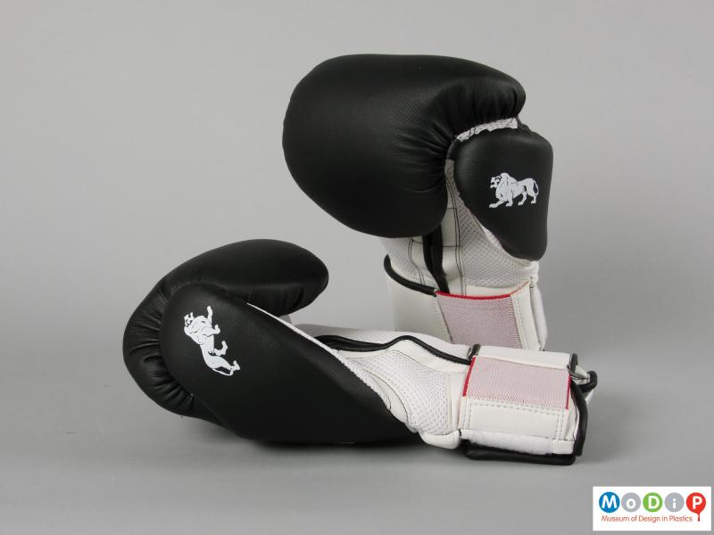 Side view of a pair of boxing gloves showing the black back section.