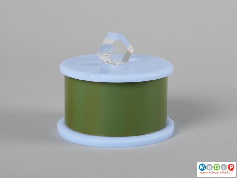 Side view of a trinket box showing the clear diamond shaped knob on the lid.