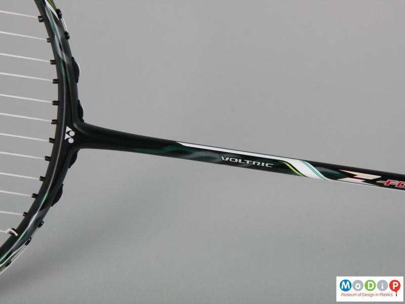 Close view of a badminton racket showing the shaft.
