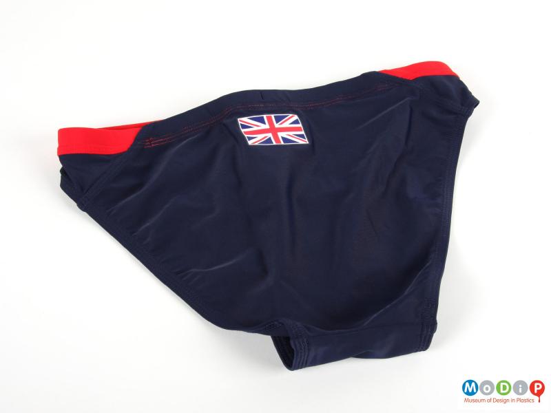 Rear view of a pair of swimming trunks showing the Union falg on the back waistband.