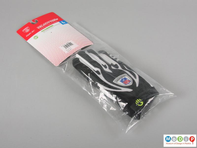Front view of a pair of wheelchair sports gloves showing the packaging.