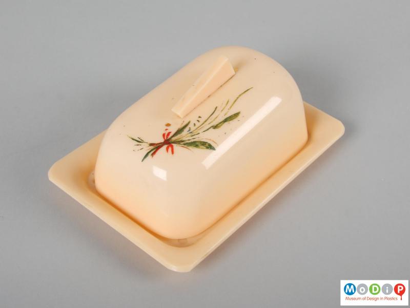 Top view of a butter dish showing the handpainted decoration on the top of the cover.