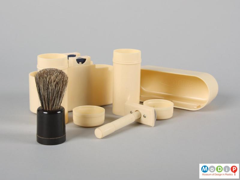 Side view of a shaving kit showing the brush, pots and razor.