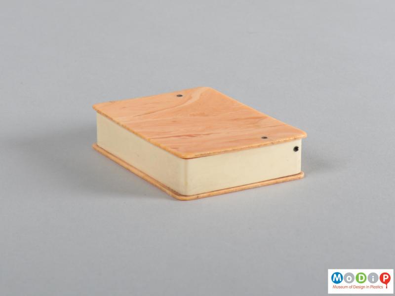 Side view of a cigaratte box showing the straight sides and overhanging lid and base.