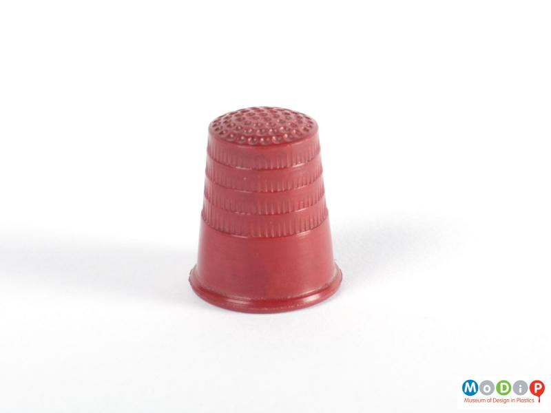 Side view of a thimble showing the tapered shape and moulded texture.