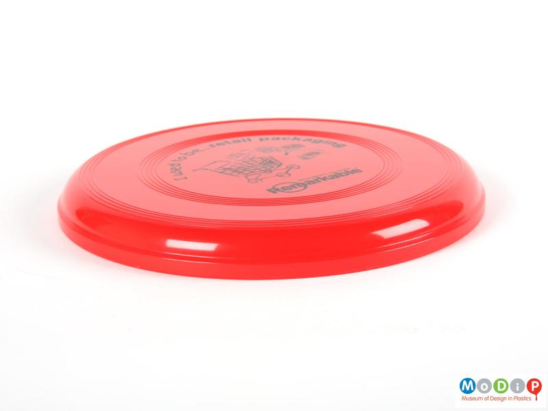 Side view of a frisbee showing the moulded grips in the top surface.