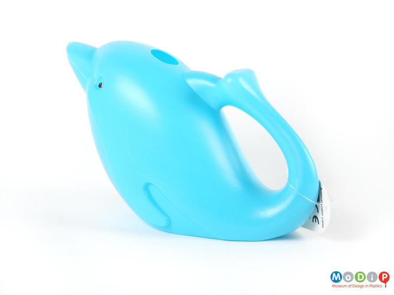 Side view of a watering can showing the tail forming the handle.
