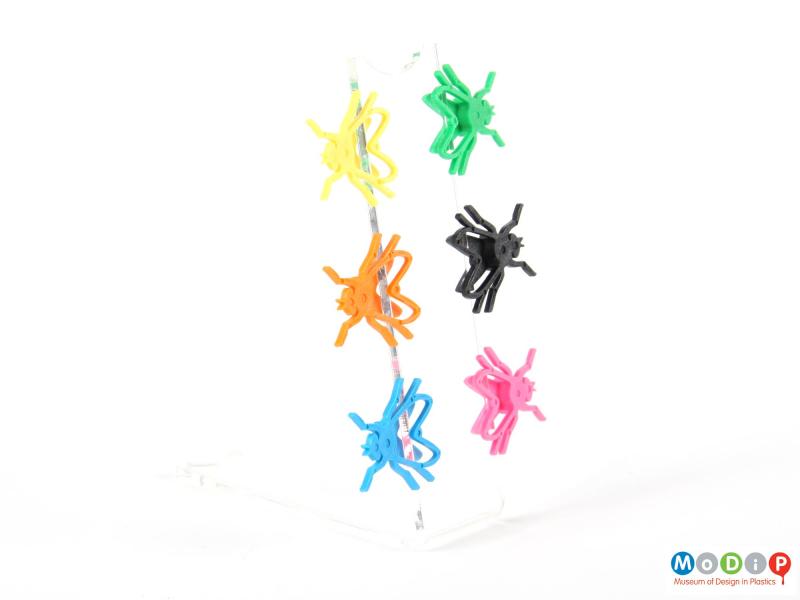 Front view of a set of Fly shaped markers showing them clipped onto a piece of acrylic.