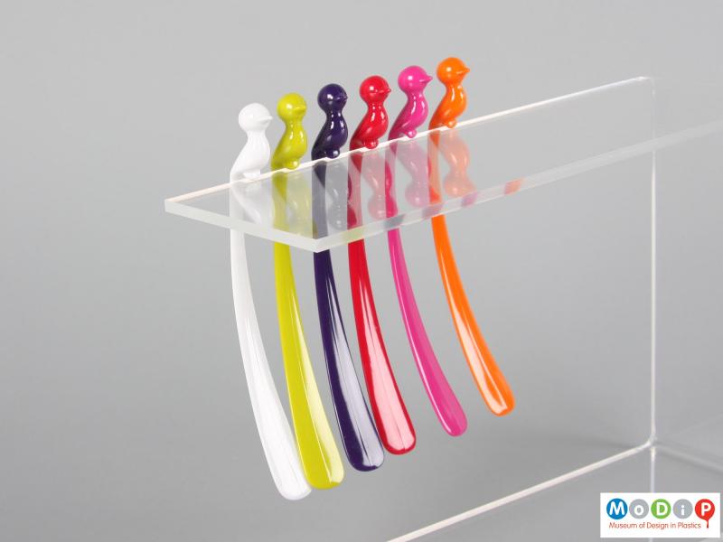 Side view of a set of cocktail stirrers showing them perched on a stand.