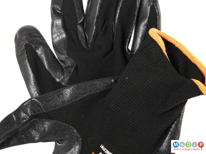 Close view of a pair of gloves showing the different material surfaces.