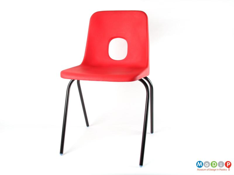 Front view of a chair showing the black legs and red seat.