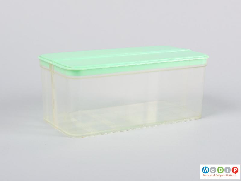Side view of a food container showing the clear base and green lid.