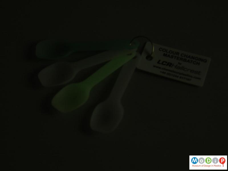 Side view of a set of spoons showing one spoon glowing in the dark.