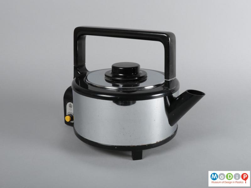 Side view of a kettle showing the square handle and round spout.