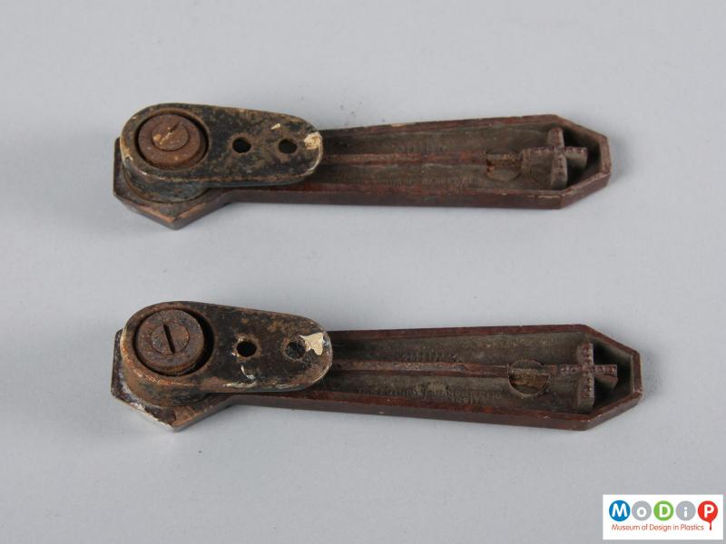 Underside view of a pair of stair clips showing the metal clip underneath.