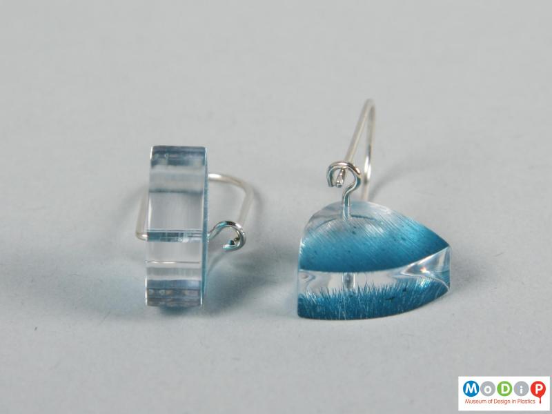 Close view of a pair of earrings showing the clear material.