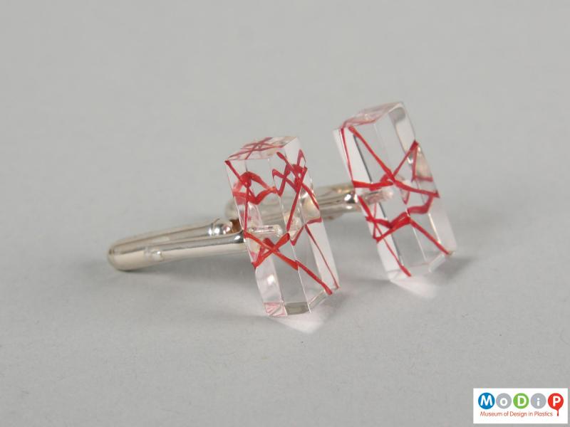 Side view of a pair of cuff links showing the clear material.