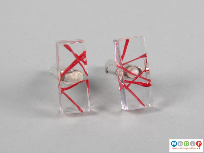 Front view of a pair of cuff links showing the red decoration.
