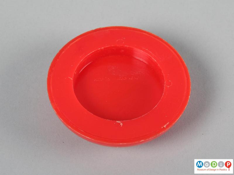 Underside view of a set of tiddlywinks showing the inside of the lid.