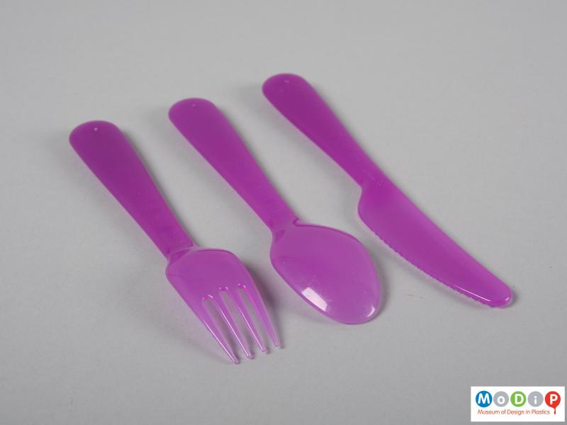 Side view of a set of cutlery showing one each knife, spoon and fork.