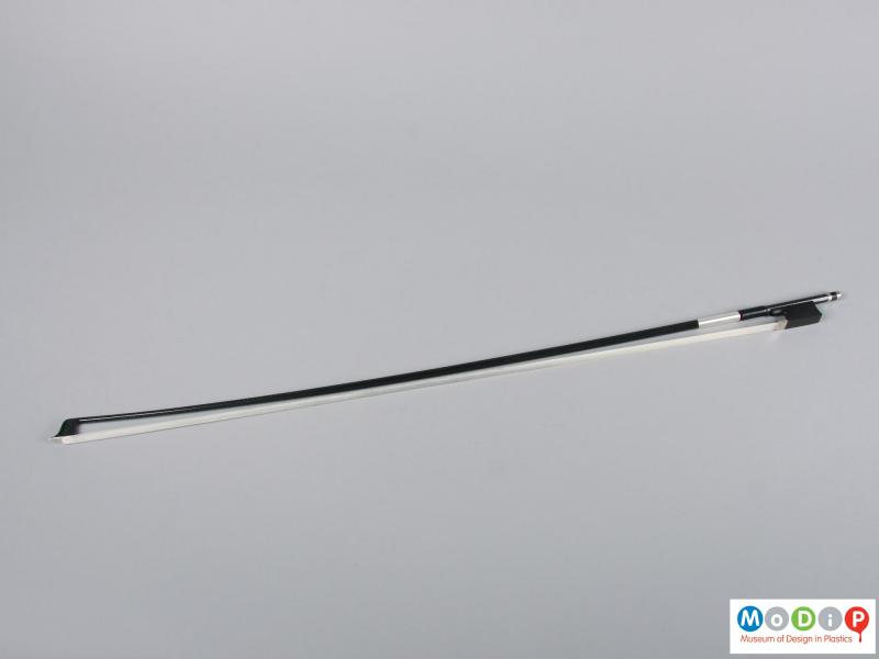 Side view of a violin bow showing the full length.