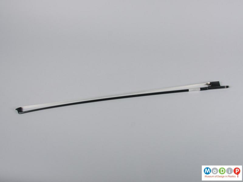 Side view of a violin bow showing the full length.