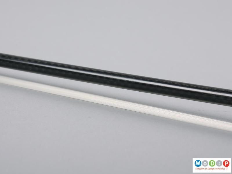 Close view of a violin bow showing the shaft.
