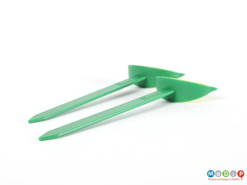 Side view of two swizzle sticks showing the lime wedges and flat sticks.