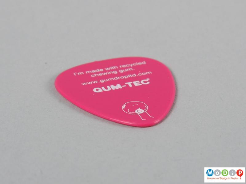 Side view of a guitar pick showing the printed text.