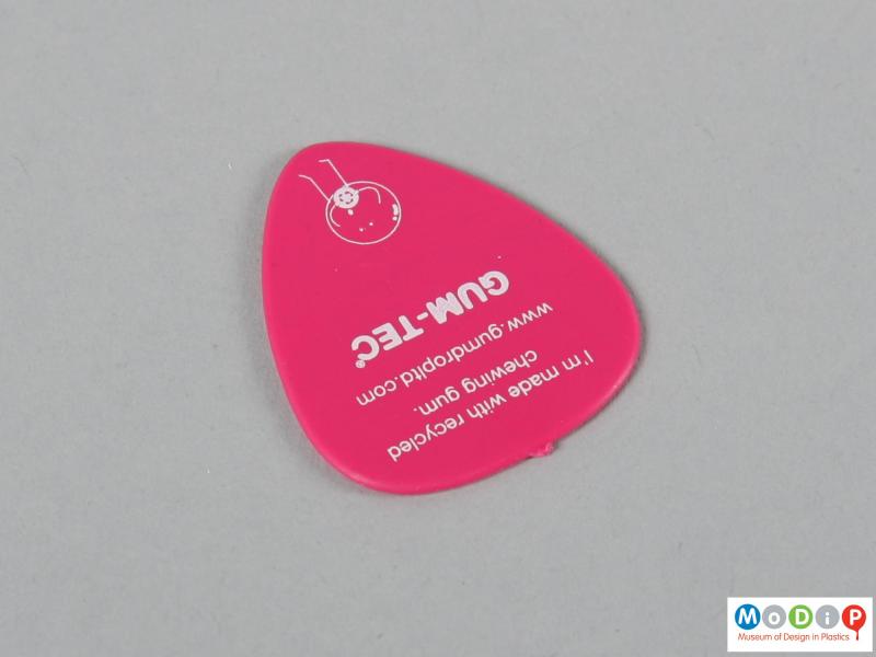 Front view of a guitar pick showing the printed inscription.